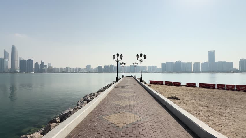 Lamp lined pier with Abu Dhabi skyline in Abu Dhabi, United Arab Emirates