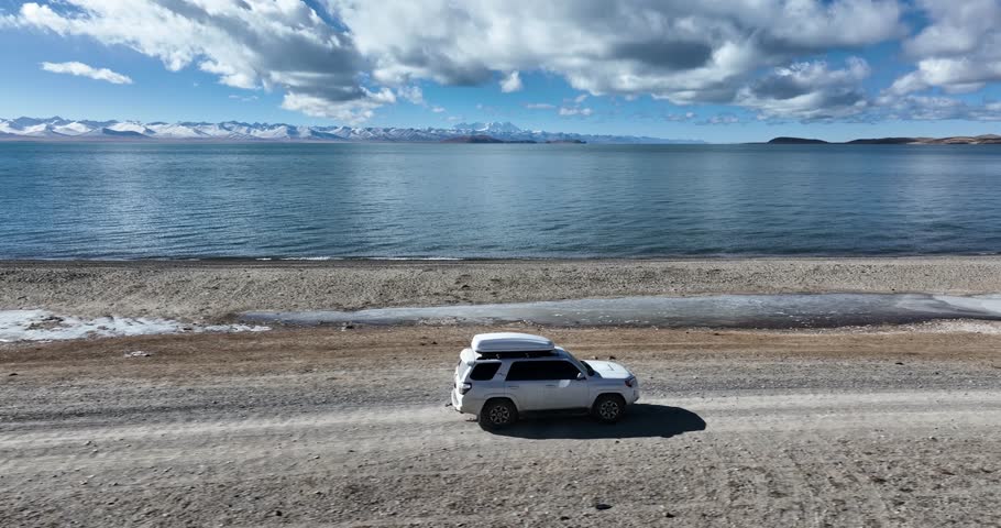 Tibet,China - November 26,2024: Driving off road car in high altitude lakeside in tibet, China 