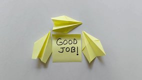 Yellow sticky note with good job message surrounded by paper airplanes isolated on white background. Concept of motivation, achievement, and encouragement. - Powered by Shutterstock - Get 15% off with code: PIKWIZARD15