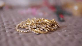 Hand Slowly Lifting Sparkling Gold Rhinestone Chain From Linen Surface, Luxury Jewelry Craft Close Up Slow Motion - Powered by Shutterstock - Get 15% off with code: PIKWIZARD15