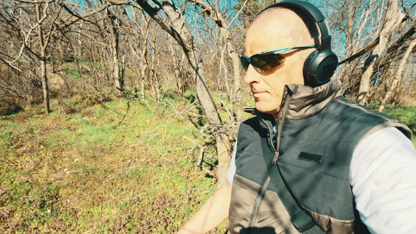 Stylish senior man in a sporty jacket exploring a forest trail. Authentic representation of active aging, vitality, and modern elderly lifestyle.