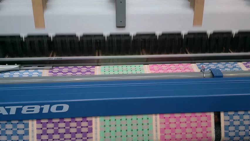 Nagoya, Japan - June 11th 2016 : Carpet Weaving Process on a Toyota Airjet Loom T810 at the Toyota Museum, Nagoya. Close-up of a colorful small carpet being woven on a modern Toyota Airjet Loom T810 machine. Recorded at the Toyota Commemorative Museum of Industry and Technology in Nagoya, Japan