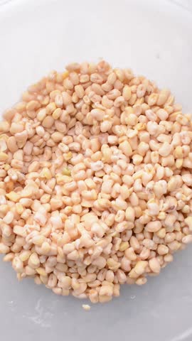 Overhead view of beans being washed, top view of honey beans being washed to make nigerian moi-moi or bean cake, process of peeling beans skin by hand