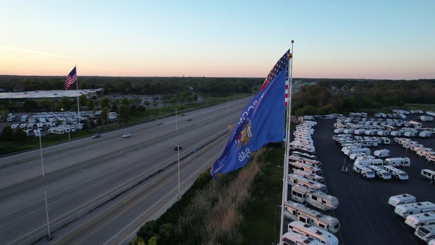 Aerial shot of American Flag and State of Wisconsin Flag in Green Bay Wisconsin at sunset.