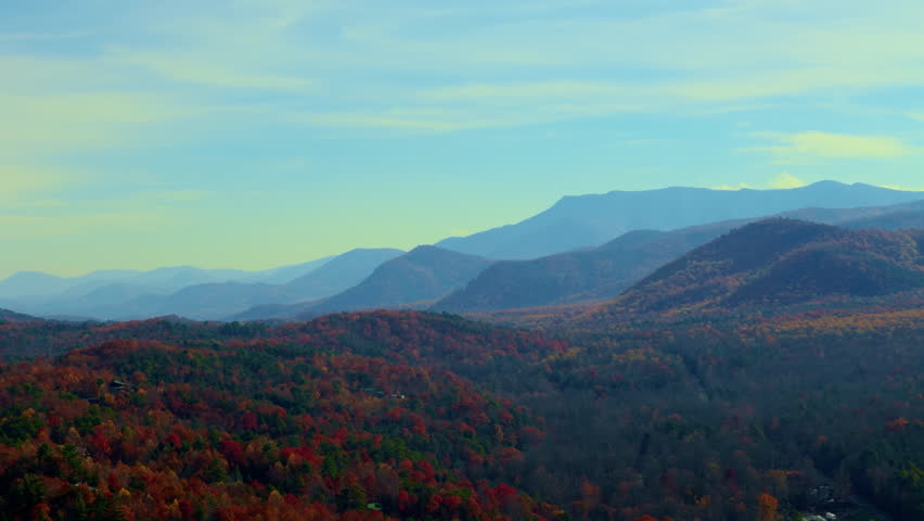 Great Smoky Mountains at morning time from drone. Layers of distant blue mountains blend with the bright blue sky. Wide drone view