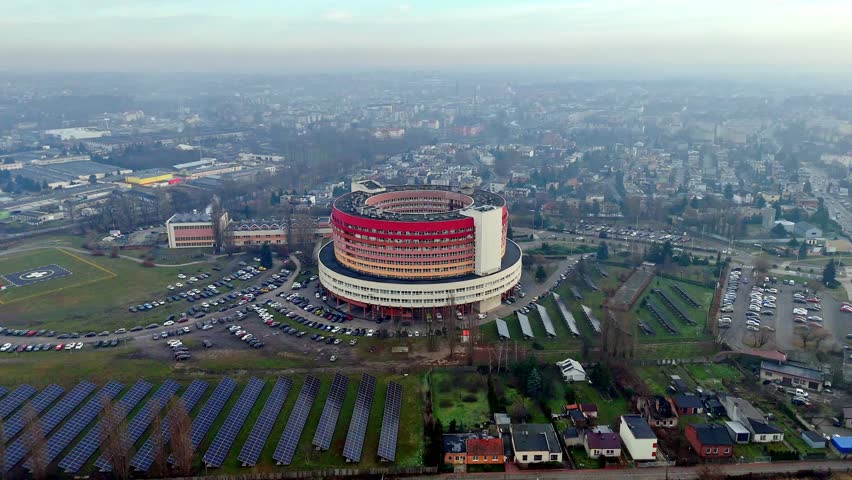 Aerial panorama of the Provincial Integrated Hospital in Kalisz, modern medical complex with photovoltaic farm and helipad, unique circular building in the city landscape, healthcare infrastructure in