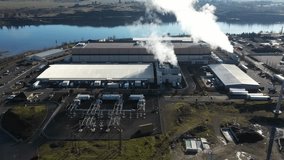 4K Aerial drone footage of a massive hyperscale data center campus with cooling steam rising from industrial cooling systems, located along the Columbia River in The Dalles, Oregon, USA. Large technology infrastructure facilities connected to a nearby electrical power substation highlight the enormous energy demand required for cloud computing, artificial intelligence processing, and global internet data storage. Modern server buildings, power grid infrastructure, and cooling technology supporting the digital economy and growing global demand for computing power - Powered by Shutterstock - Get 15% off with code: PIKWIZARD15