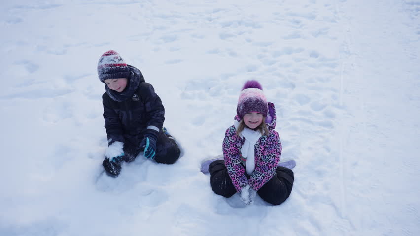 Children playing snowballs in a snowy forest. Family walking together in winter fooling around and throwing snow, happy and cheerful.