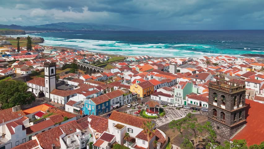 Aerial view of Ribeira Grande city on Sao Miguel Island, Azores, Portugal. Traditional white buildings along the Atlantic coast with lush volcanic hills.