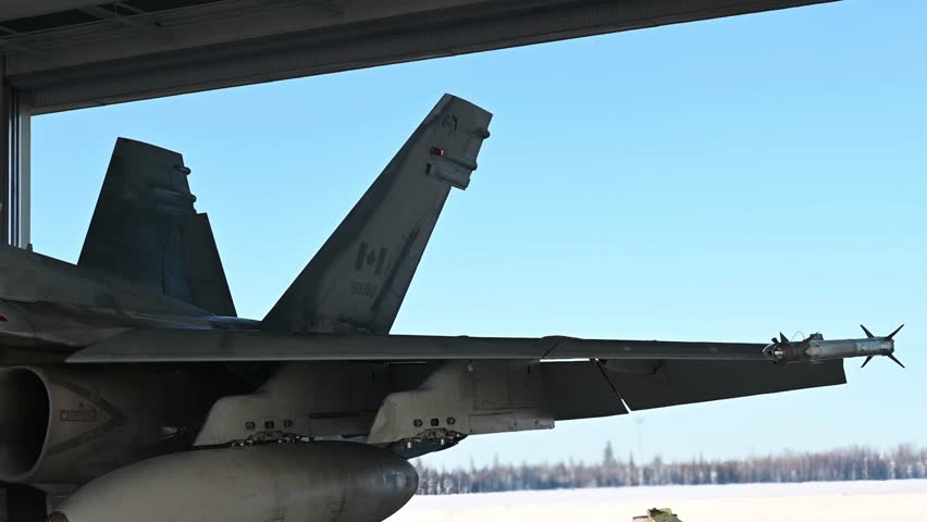 Royal Canadian Air Force CF-18 Hornets launched at a snowy airport.