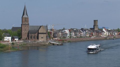 Skyline Emmerich, Germany + tourist boat cruising river Rhine.