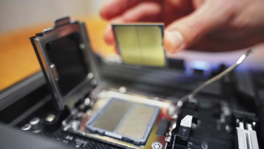 Macro of a technician installing a CPU. Precision hardware assembly. IT tutorials, hardware news, and PC building guides