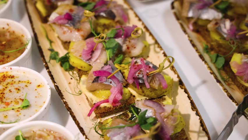 Traditional Russian cuisine dishes on a New Year table, dressed herring salad, kholodets brawn, russian snacks, olivier salad and homemade pickles on catering table banquet, party event celebration