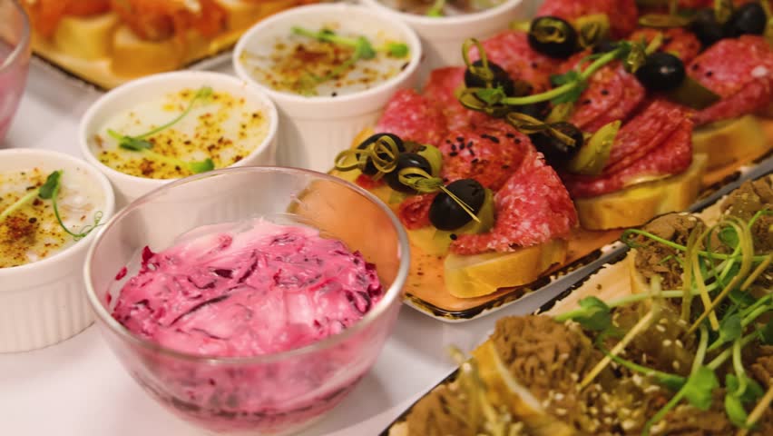 Traditional Russian cuisine dishes on a New Year table, dressed herring salad, kholodets brawn, russian snacks, olivier salad and homemade pickles on catering table banquet, party event celebration
