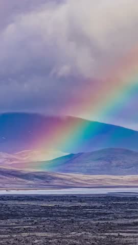 Vertical Rainbow Over Mountain Landscape Under Storm Clouds