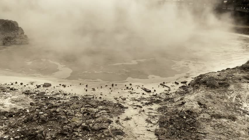 High angle view of Sikidang Crater Dieng with misty sulfur fumes and rocky terrain.