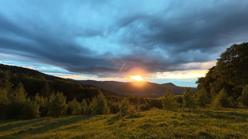 Amazing summer mountains during cinematic beautiful warm sunset. Sunsets over horizon during dusk or dawn hour. Peaceful nature and outdoor camping vibes