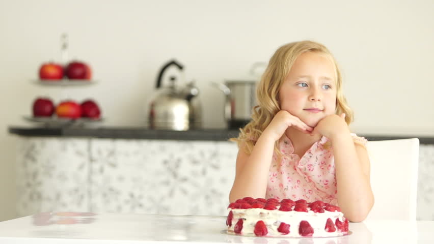Little girl admiring large strawberry gateau
