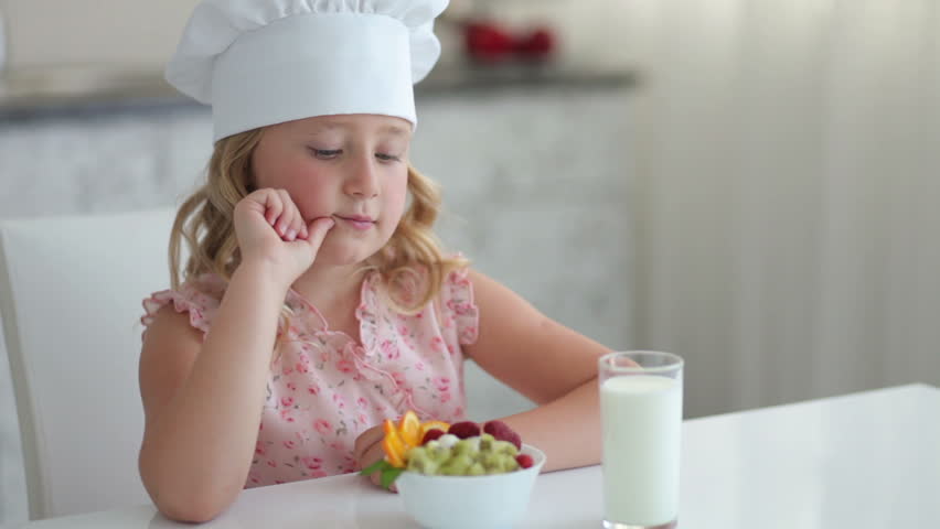 Girl with fruit yogurt and a glass of milk
