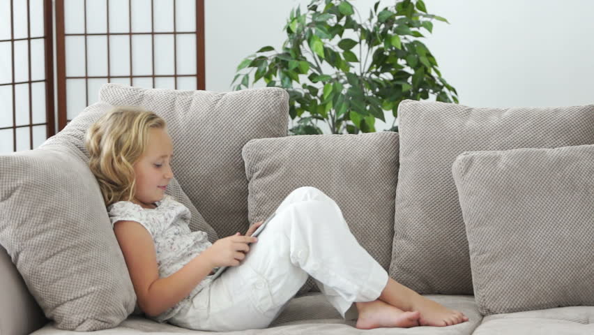 Girl with tablet pc on sofa
