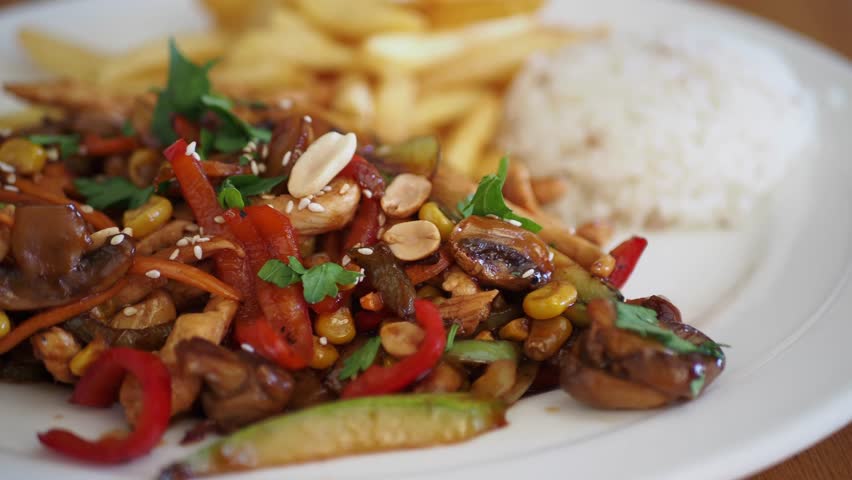 Delicious stir fry with vegetables and rice served with fries
