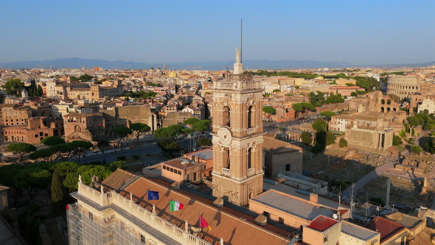 Aerial view of Palazzo Senatorio tower on Capitoline Hill in Rome Italy overlooking ancient ruins, historic buildings and dense urban scenery.