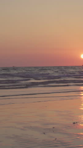 Vertical Screen : Young Asian people running on beach to the sea, friends happy relax having fun playing on beach near sea when sunset in evening. Lifestyle friends travel on beach concept.