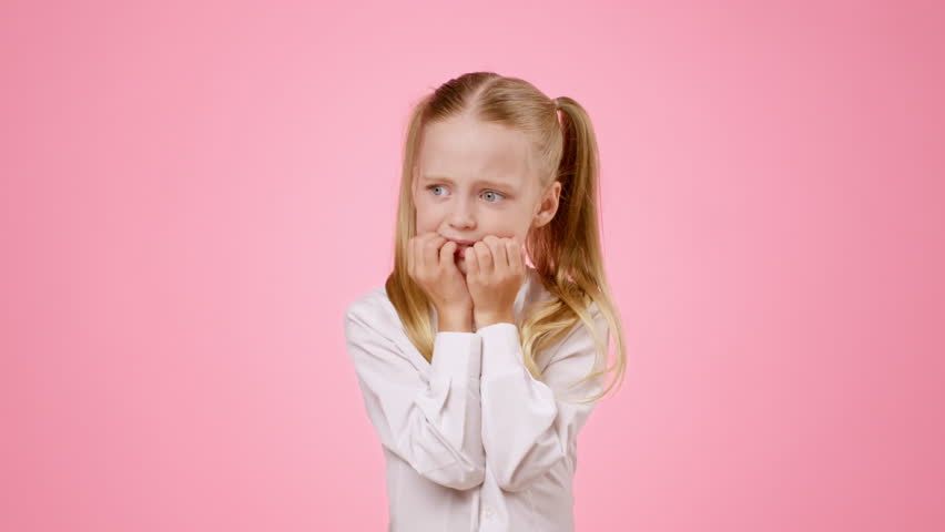 Girl With Blonde Hair Showing Nervous Expression Against Pink Background
