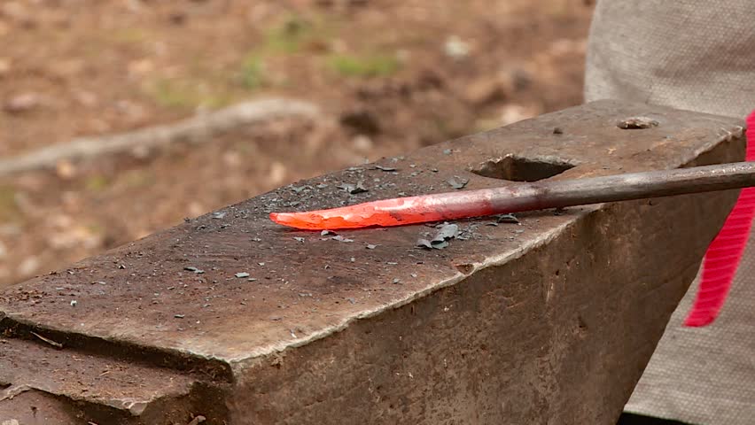 a blacksmith forges a metal product on an anvil