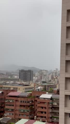 Vertical Video - Lightning strike over Taipei city during a gloomy daytime thunderstorm