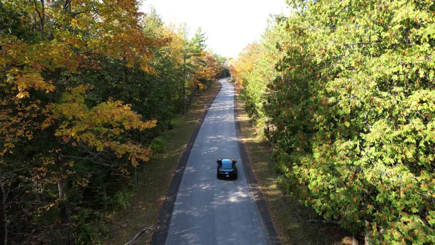 Aerial view of Door County Wisconsin Country roads in Autumn.  Dramatic view of black car driving on warm fall sunny day.
