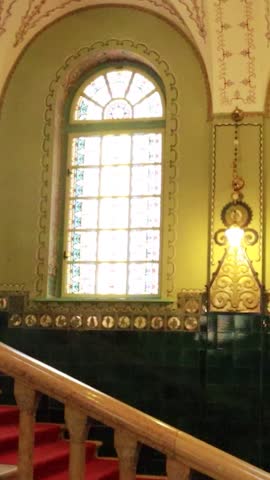 Vertical shot of stained glass window and vintage light fixture in synagogue