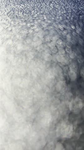 Abstract moving bokeh background. Dark silver blurred lights zooming forward animation.