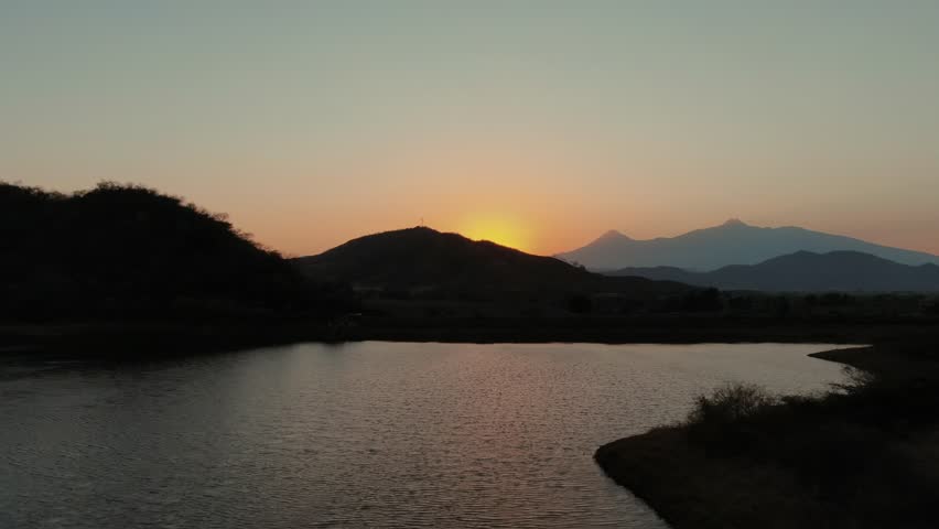 Mountain Silhouettes At Sunset In Huizilacate Dam, Tecalitlan, Jalisco, Mexico. Aerial Drone Shot