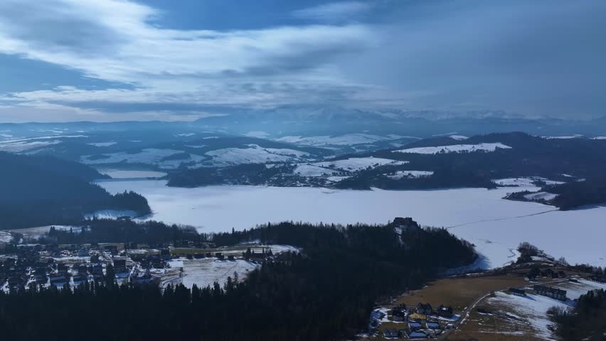 Aerial view of snowy mountains and a frozen lake in the Swiss Alps during winter