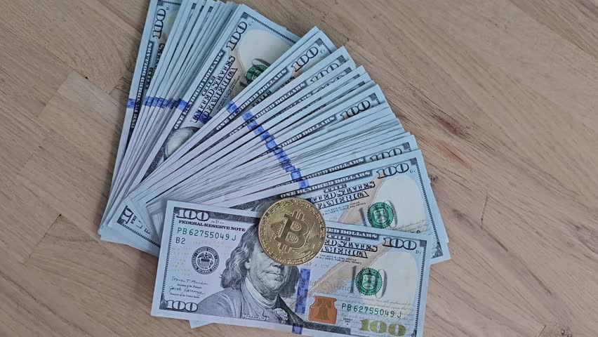 Stacks of cash with a Bitcoin coin on a wooden table showing the contrast between traditional and digital currency