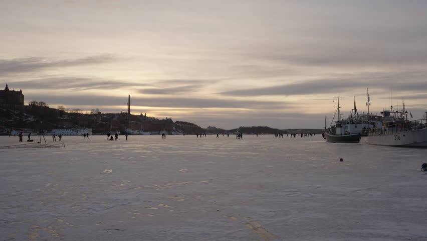 People enjoying a sunset winter evening on the ice.
