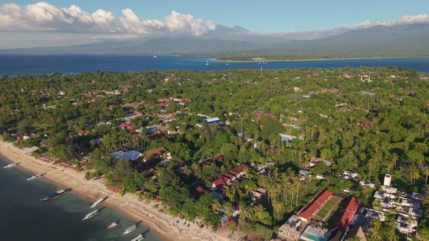 Aerial drone footage of Gili Air island, showing sandy beach, resorts, and distant Lombok
