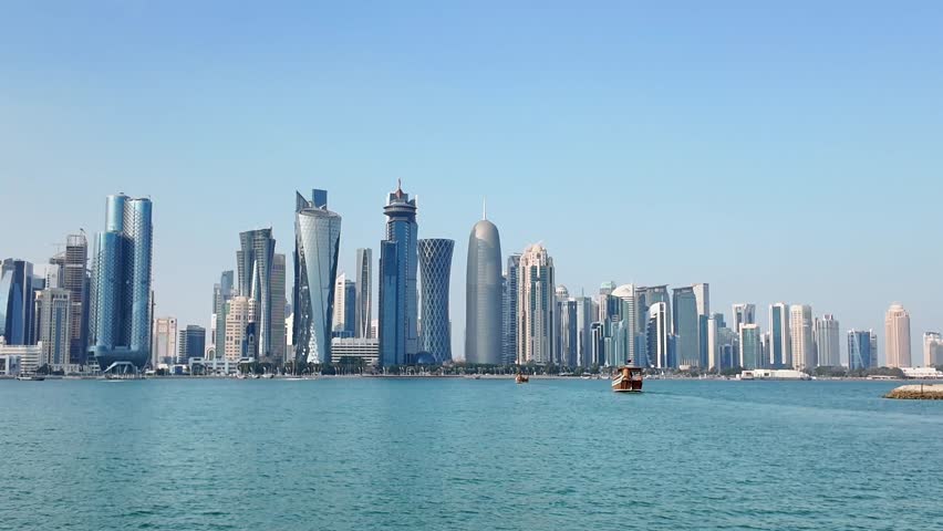 Stunning cinematic footage capturing the captivating skyline of Doha, Qatar, with a traditional dhow boat gracefully cruising on the turquoise waters of Doha Bay