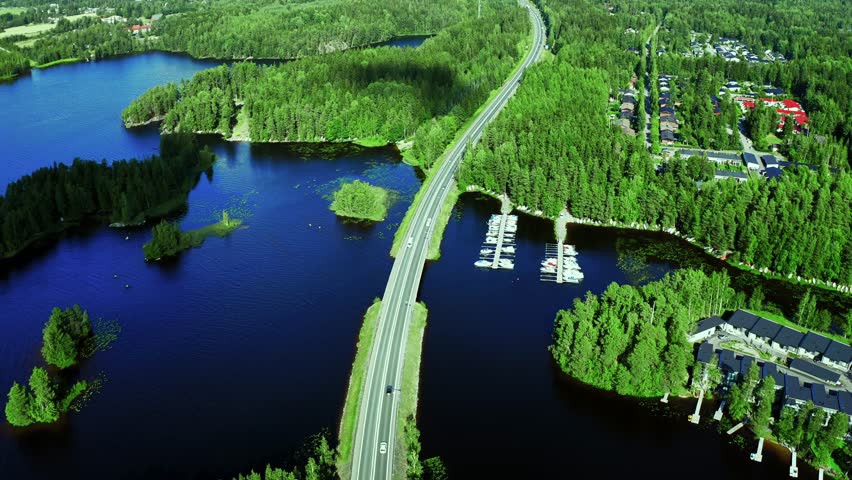 Aerial View of a Scenic Road Winding Through Lush Forests and Serene Lakes in Nature in Finland