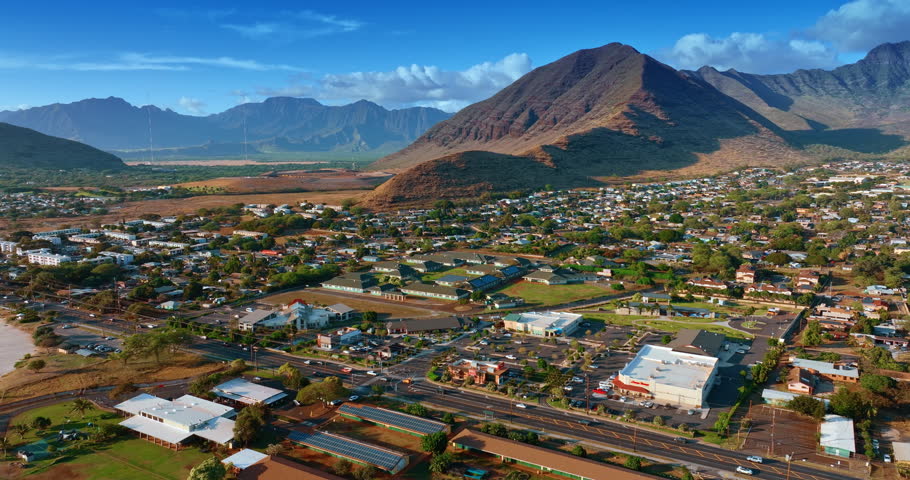 Going up over the urban landscape of Honolulu, Hawaii, USA. Rugged bare mountains surround the city scenery.