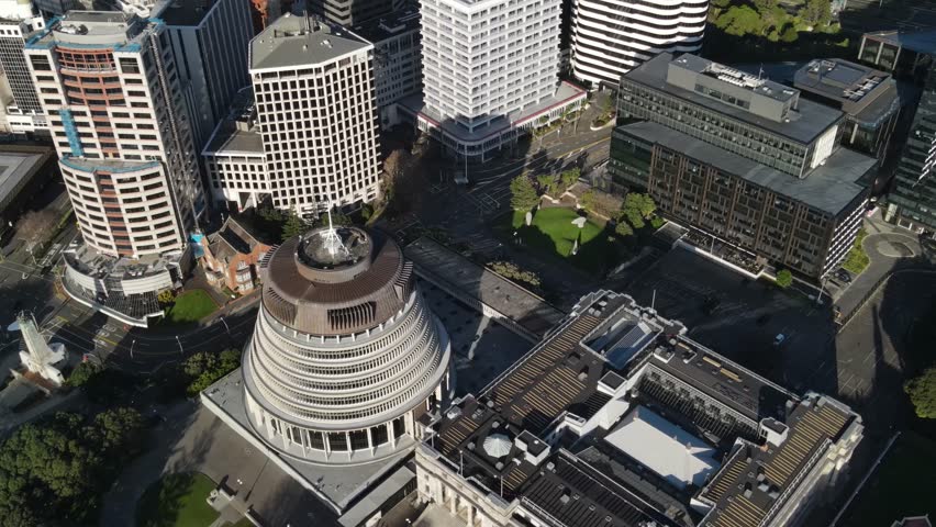 Birds eye flyover Beehive and roofs of buildings in Wellington downtown. New Zealand capital city.