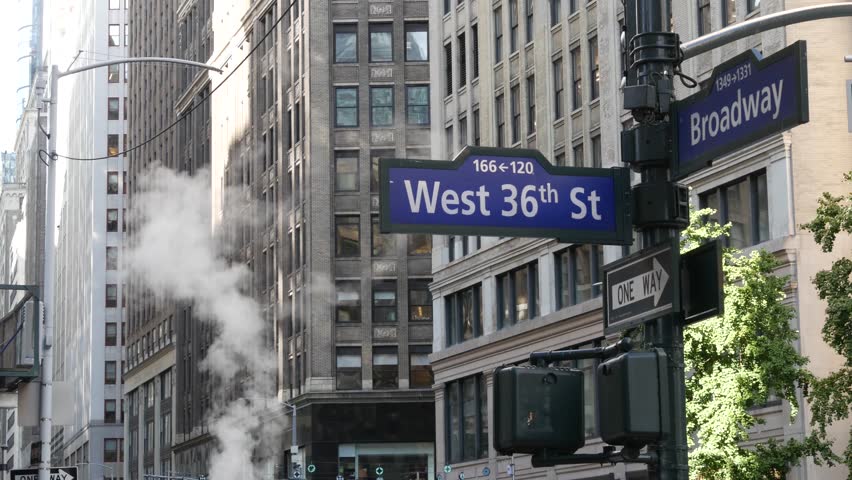 New York City Broadway and 36 street sign on Manhattan, United States. Urban road sign in american city. Traffic sign in Midtown of NYC. Building architecture, district near Herald Square. Hot steam.