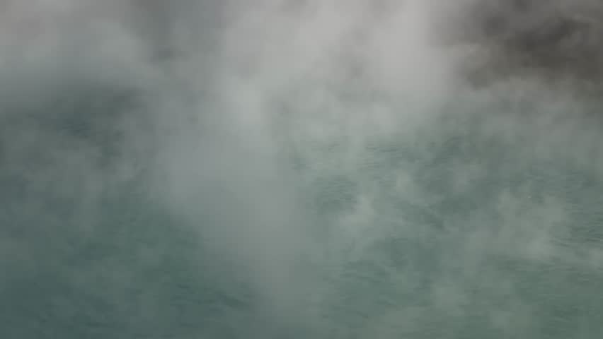 Stunning turquoise blue geothermal water of Umi Jigoku (Sea Hell) with thick rising steam in winter, Beppu, Oita, Japan