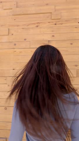 Beautiful young asian woman spinning, dancing, and smiling at the camera. She expresses happiness, freedom, and positive energy outdoors
