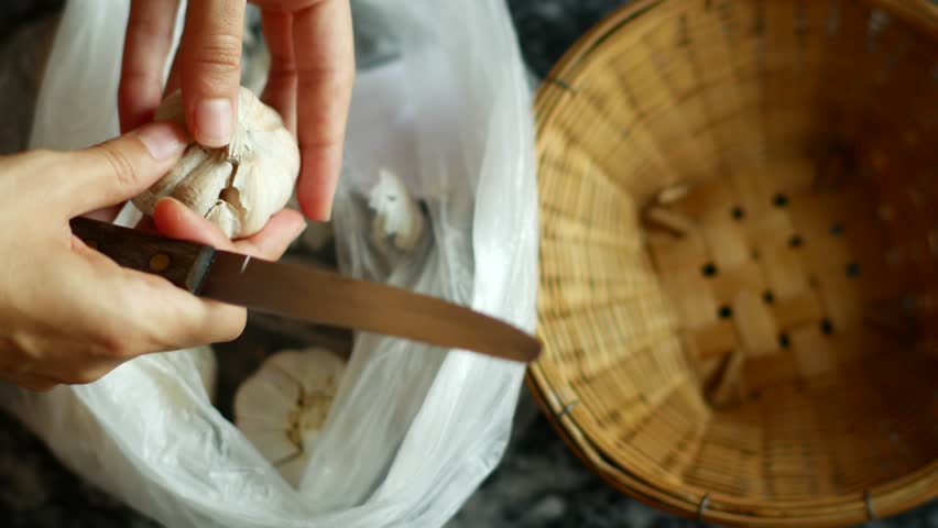 Woman Peeling Garlic with hands and knife