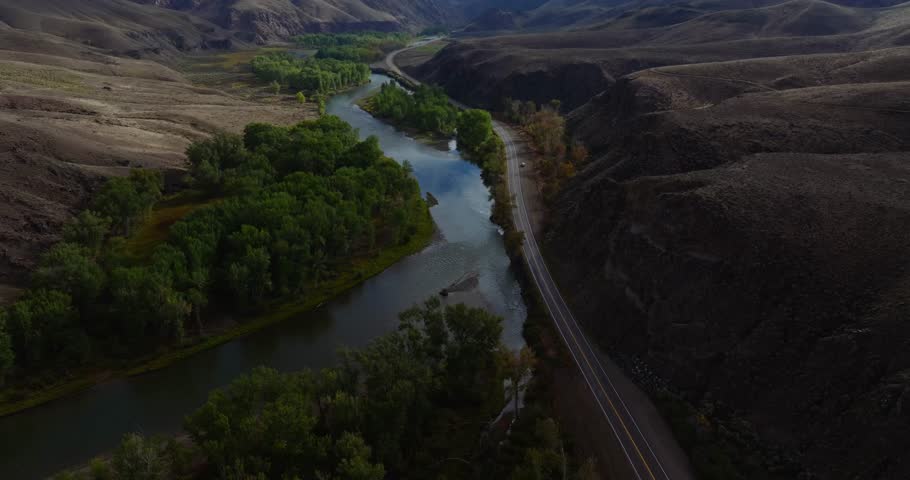 Aerial view of river curve and parallel highway in Idaho canyon