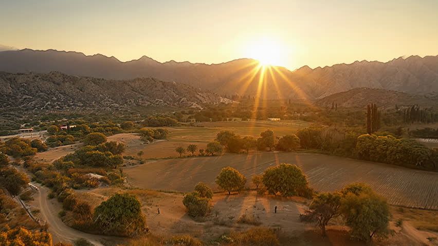 Sunset Over Mountain Valley And Farmland