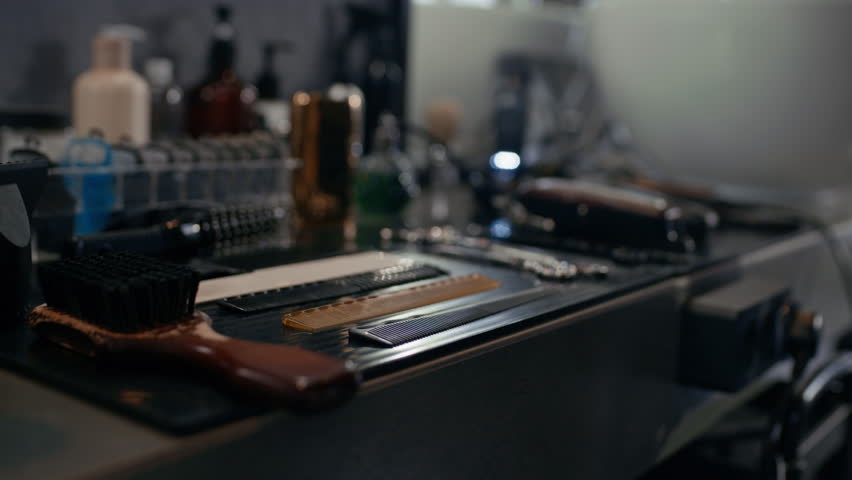 Close up of anonymous barber taking professional scissors and comb during workday