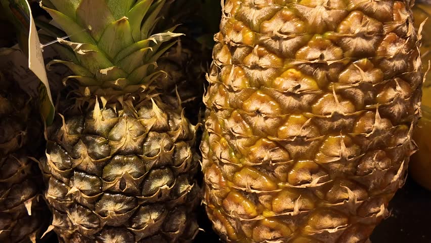 A customer chooses in a supermarket fresh ripe pineapple